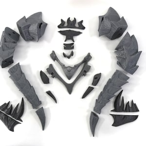 May include: A set of 12 gray plastic pieces that can be assembled into a dragon figurine. The pieces are detailed with scales and spikes.