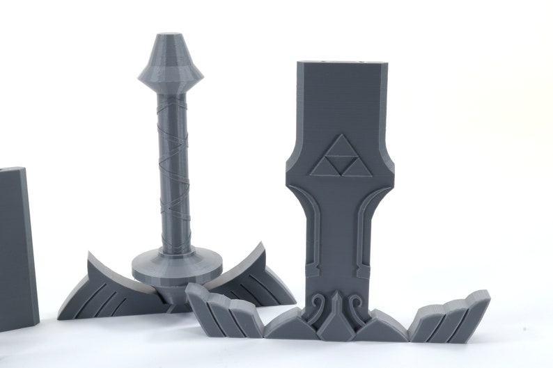 Puede incluir: Un modelo de pl&aacute;stico gris de la Espada Maestra de la serie de videojuegos The Legend of Zelda. La espada est&aacute; dividida en cinco piezas, incluyendo la hoja, la empu&ntilde;adura y la pomo.