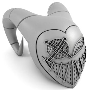 Puede incluir: Una m&aacute;scara gris impresa en 3D con una cara en forma de coraz&oacute;n, que presenta una sonrisa cosida y dos agujeros para los ojos con un patr&oacute;n de cruz.