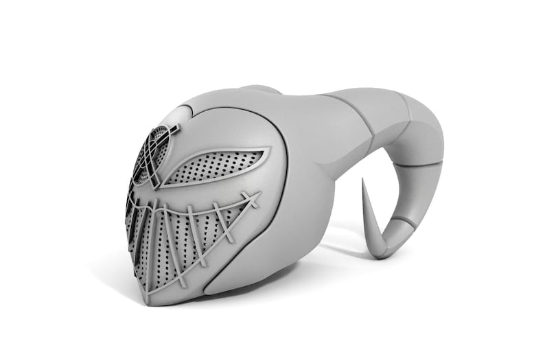 Puede incluir: Una m&aacute;scara gris impresa en 3D con un dise&ntilde;o de cuernos. La m&aacute;scara tiene un patr&oacute;n geom&eacute;trico detallado en la parte delantera, que incluye un &aacute;rea de ojos de malla y una boca cosida.