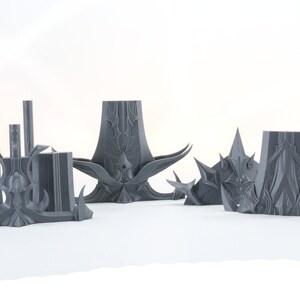 Puede incluir: Un conjunto de cinco piezas de pl&aacute;stico gris impresas en 3D, que se asemejan a un castillo o fortaleza de fantas&iacute;a. Las piezas est&aacute;n detalladas con dise&ntilde;os intrincados y puntas afiladas.