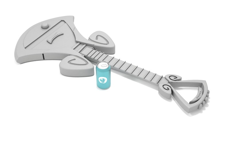 May include: A gray, stylized guitar with a unique design, lying on a white surface. A blue can with a white logo is next to the guitar.