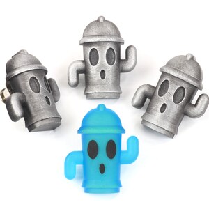 May include: Four small figurines of fire hydrants, three are silver and one is blue. The figurines have cartoon faces with eyes, a mouth, and a single arm raised.