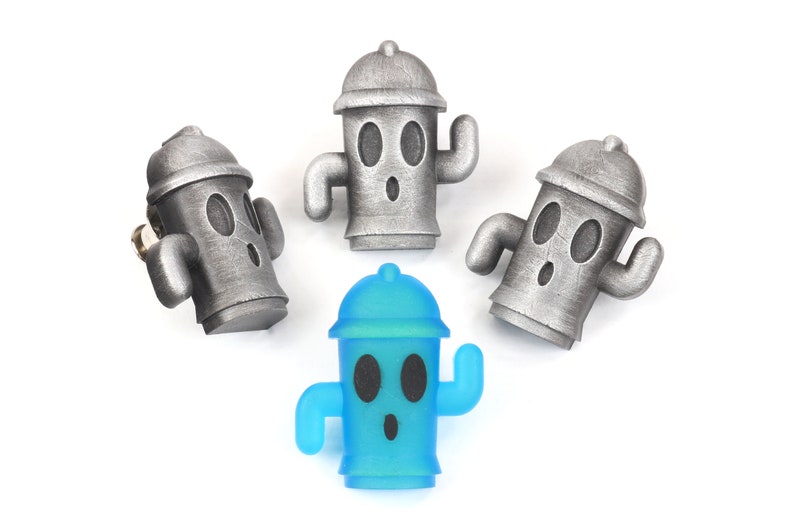 May include: Four small figurines of fire hydrants, three are silver and one is blue. The figurines have cartoon faces with eyes, a mouth, and a single arm raised.