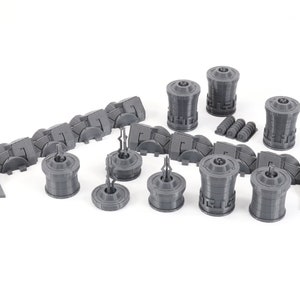 May include: A set of gray 3D printed miniature buildings and walls for a tabletop game or diorama. The set includes a variety of shapes and sizes, including towers, walls, and gates.