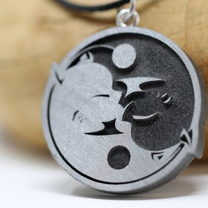 May include: A silver pendant necklace featuring a yin yang symbol with a dragon and a phoenix design.