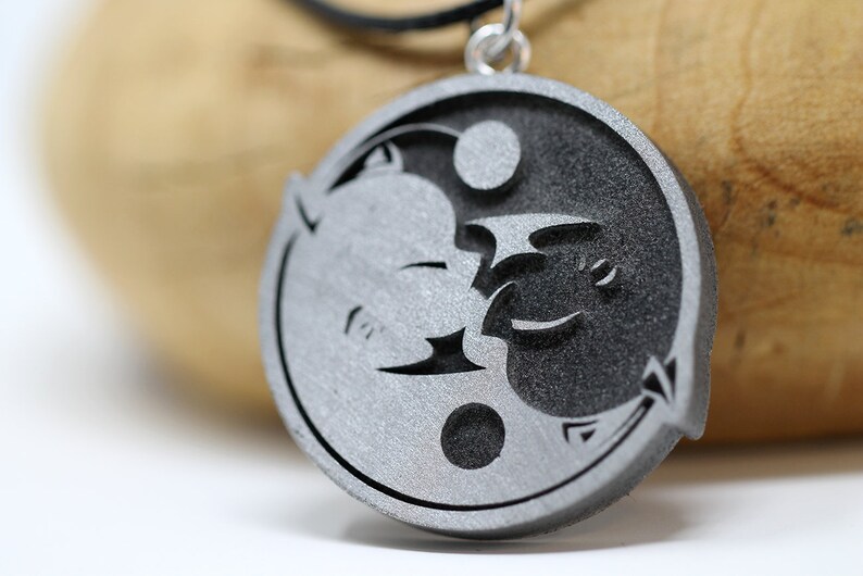 May include: A silver pendant necklace featuring a yin yang symbol with a dragon and a phoenix design.