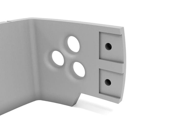 May include: A light gray, angular architectural component with three circular indentations and two square holes. The object has a curved edge and appears to be made of a solid, possibly manufactured, material. The design is minimalist and modern.
