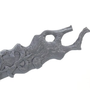 May include: A gray 3D printed sword with a detailed, organic design. The blade is curved and has a textured surface.