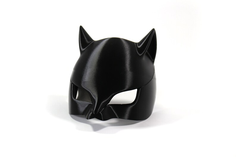 May include: A black plastic cat mask with pointy ears and eye holes.