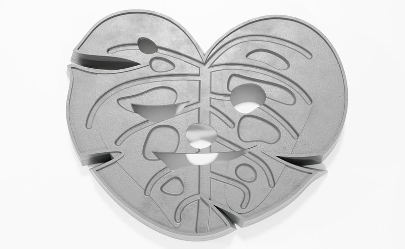 May include: A gray, heart-shaped, decorative wall hanging with a cutout design resembling a monstera leaf.