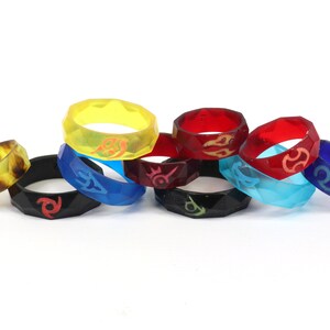 May include: Eight colorful silicone rings with different designs. The rings are stacked on top of each other.