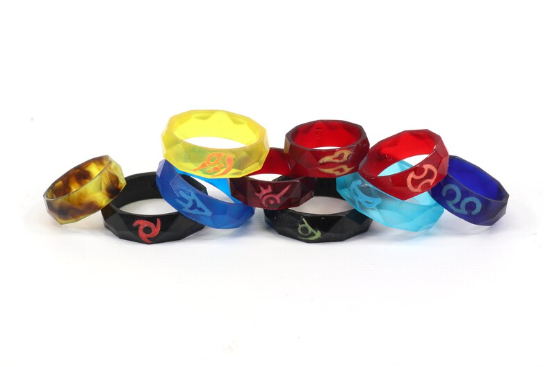 May include: Eight colorful silicone rings with different designs. The rings are stacked on top of each other.