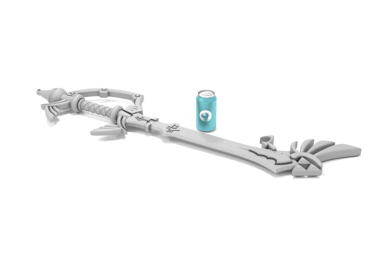 K&ouml;nnte beinhalten: Eine wei&szlig;e Plastik-Replik der Kingdom Key, ein schl&uuml;sself&ouml;rmiges Schwert aus der Kingdom Hearts-Videospielserie. Das Schwert liegt auf einer wei&szlig;en Oberfl&auml;che neben einer blauen Dose.