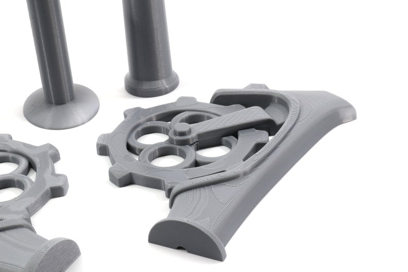 May include: A set of gray 3D printed gears and pipes. The gears have a detailed design with multiple holes and a lever.