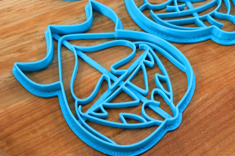May include: Blue plastic cookie cutter shaped like a leaf with intricate details.