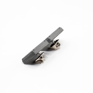 Peut inclure: Un bouton de pin en m&eacute;tal gris avec deux attaches en m&eacute;tal.