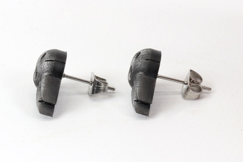 Peut inclure: Une paire de boucles d'oreilles en argent avec un motif de cr&acirc;ne 3D textur&eacute; noir.