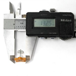 May include: A close-up of a digital caliper measuring a small wooden object. The caliper reads 13.25 mm.