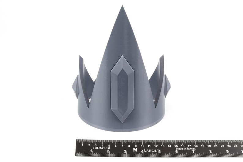 May include: A gray 3D printed crown with a pointed top and a large, rectangular gem in the center.