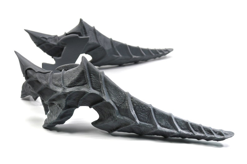 May include: Two grey, 3D printed, dragon tail-like sculptures with a spiky, textured surface.