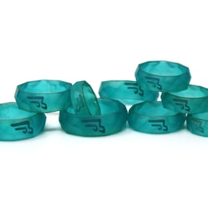 May include: A group of eight teal blue silicone rings with a black logo of a stylized bird with wings spread. The rings are stacked on top of each other.