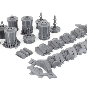 May include: A set of gray 3D printed model pieces for a sci-fi spaceship. The set includes a variety of shapes, including cylinders, squares, and rectangles. The pieces are designed to be assembled together to create a complete spaceship model.