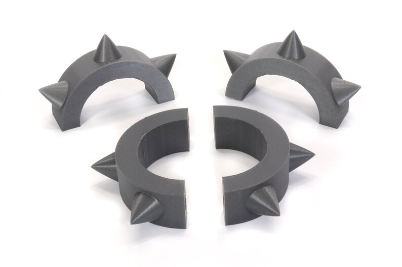 May include: Four grey plastic spiked rings, two are half circles and two are full circles.