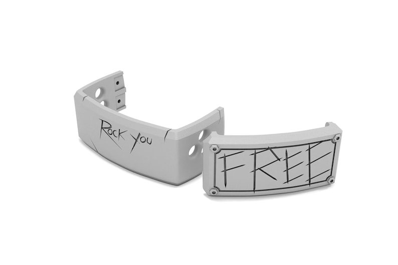 May include: Two light gray, curved, plastic pieces. One piece has the text "Rock you" in black, the other piece has the word "FREE" in black. Both pieces have a few holes and are on a white background.