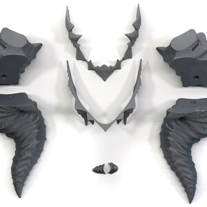 May include: A set of six gray 3D printed pieces that can be assembled into a decorative wall sculpture. The pieces are shaped like jagged rocks and horns.
