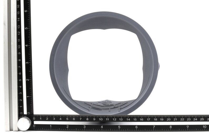 May include: A gray plastic ring with a square opening in the center. The ring is about 4 inches in diameter.