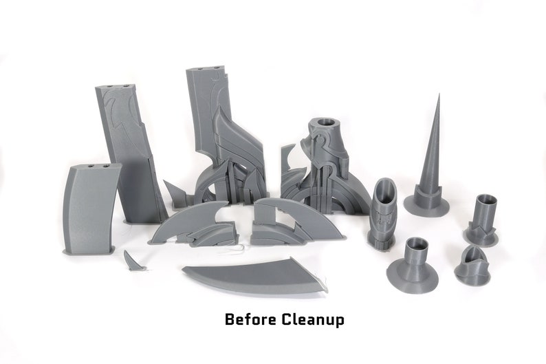 May include: A set of 14 gray 3D printed pieces, likely for a model or sculpture. The pieces are arranged on a white surface. The text "Before Cleanup" is visible at the bottom of the image.