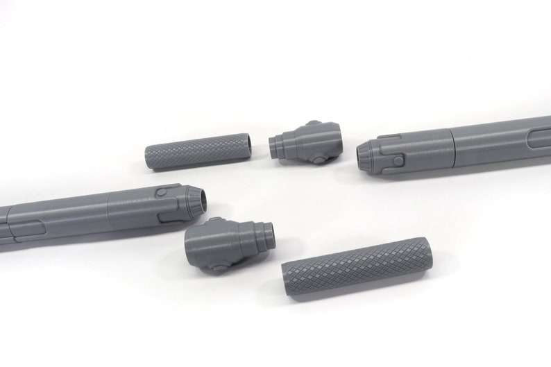 K&ouml;nnte beinhalten: Ein zerlegter grauer 3D-gedruckter Stift mit einem strukturierten Griff und einer abnehmbaren Spitze. Der Stift besteht aus f&uuml;nf Teilen.