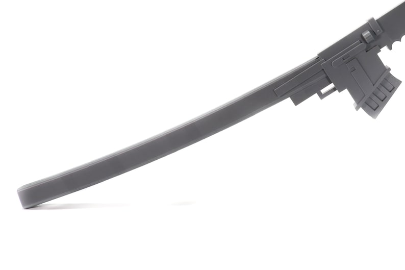 Puede incluir: Una pistola de juguete de pl&aacute;stico gris con un ca&ntilde;&oacute;n largo y un mango detallado.