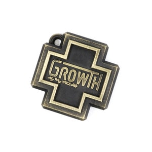 May include: A black metal charm in the shape of a cross with a gold border. The word "GROWTH" is written in gold lettering inside the cross.