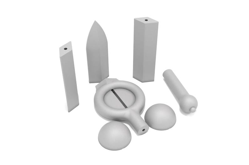 May include: A set of seven gray ceramic pieces, including a ring with a slit, two spheres, a cylinder, and three rectangular prisms.