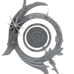 May include: A gray, decorative celestial-themed object with a spiral design. It features star and leaf accents, with a central circular element. The object has a detailed, textured surface and is set against a white background.