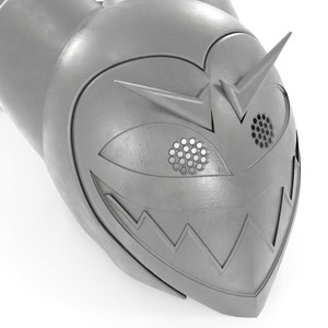 May include: A silver-colored helmet with a menacing grin and a single eye with a grid pattern. The helmet has a pointed top and a sharp, angular design.
