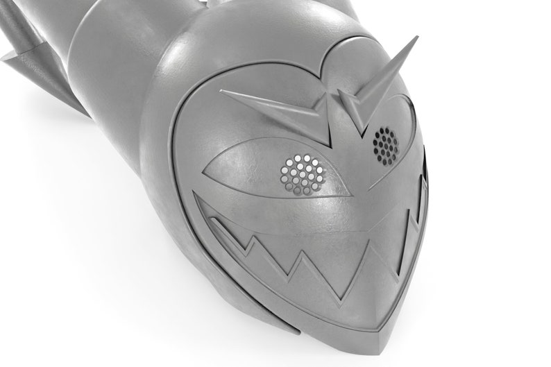 May include: A silver-colored helmet with a menacing grin and a single eye with a grid pattern. The helmet has a pointed top and a sharp, angular design.