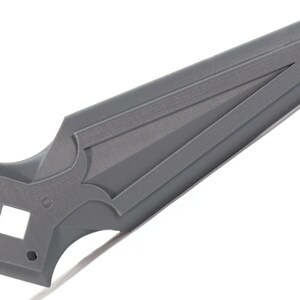 May include: A gray plastic sword with a pointed tip and a decorative design on the handle.