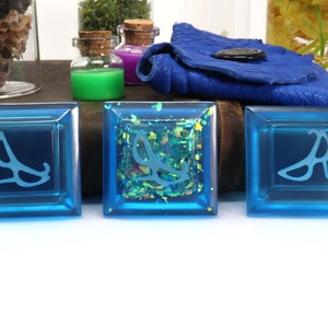 May include: Three blue square tiles with a white design of a high heel shoe on each. The middle tile has a glittery blue background.