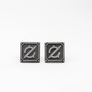 May include: Two silver-toned cufflinks with a stylized letter Z in a square frame.