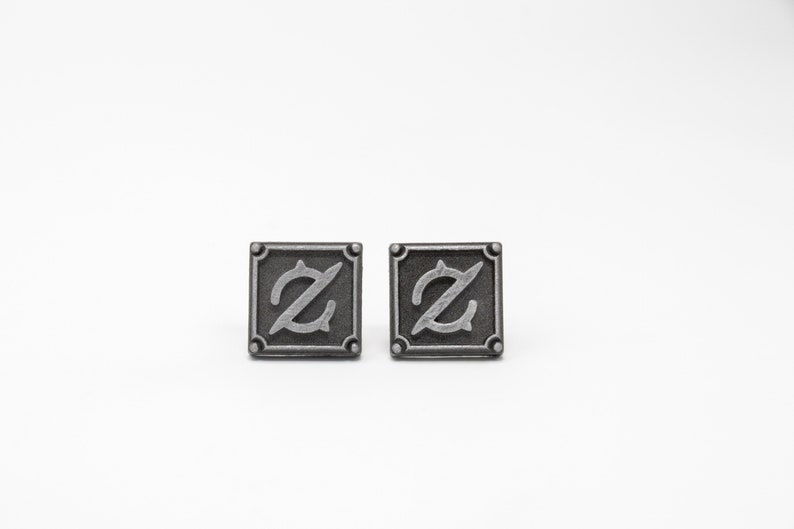 May include: Two silver-toned cufflinks with a stylized letter Z in a square frame.