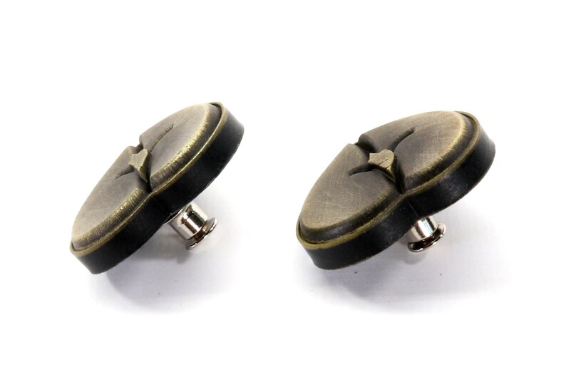 May include: Two antique gold-toned heart-shaped buttons with black trim and a metal shank.