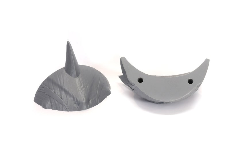 May include: Two gray plastic pieces that can be assembled to create a 3D model of a dinosaur horn.