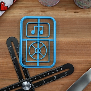 May include: A blue plastic cookie cutter shaped like a vintage radio with a music note and a record player design.