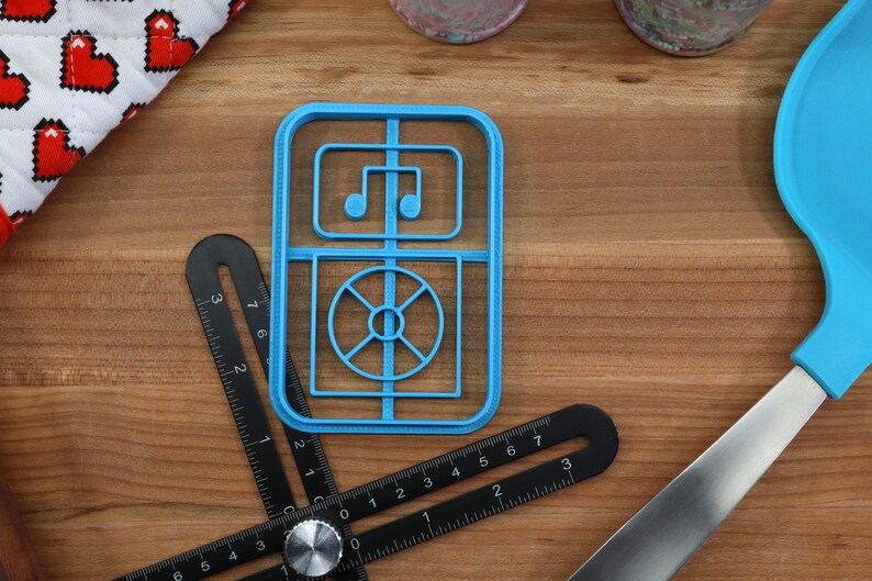 May include: A blue plastic cookie cutter shaped like a vintage radio with a music note and a record player design.