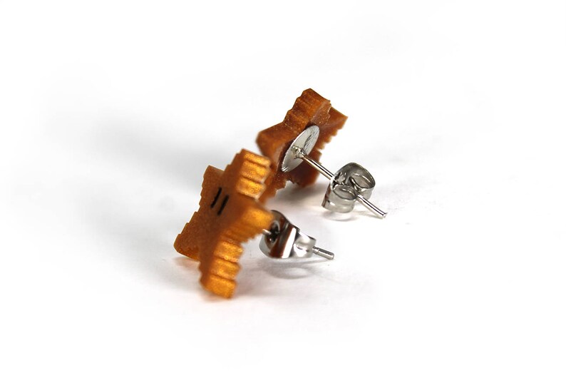 May include: A pair of gold star-shaped earrings with silver posts and backs.