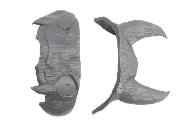 May include: Two gray plastic pieces that can be assembled to form a horned headdress. The pieces are textured to resemble stone.