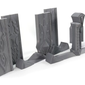 May include: A set of gray plastic pieces for building a miniature castle wall. The pieces have intricate designs and are ready to be assembled.